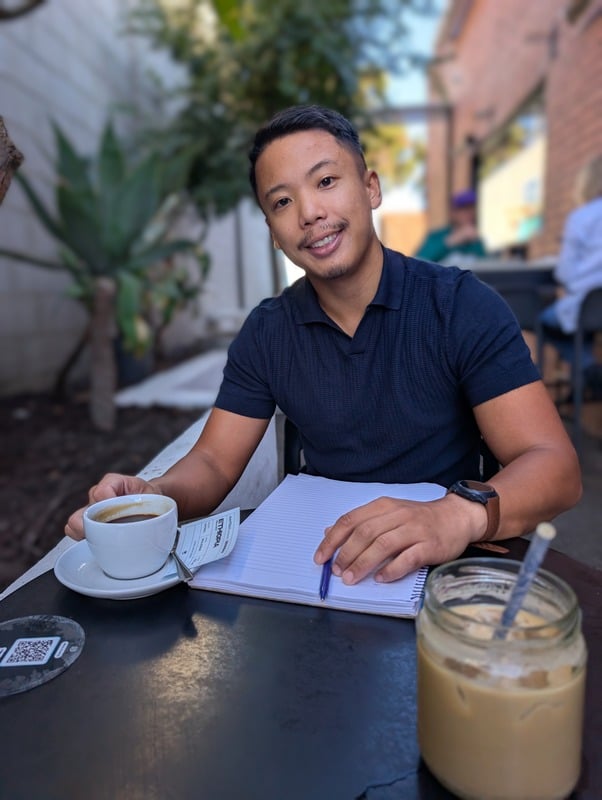 Jose, performance coach, seated at a Perth café with a notebook